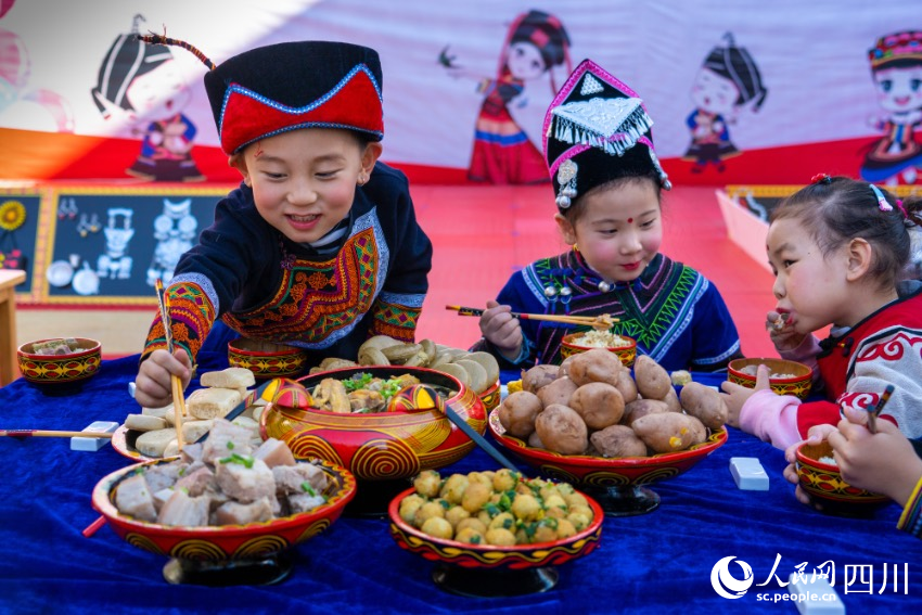 彝族年被稱為“嘴巴的節(jié)日”，圖為幼兒園內(nèi)的小朋友們?cè)谄穱L彝族傳統(tǒng)美食。范艷民攝