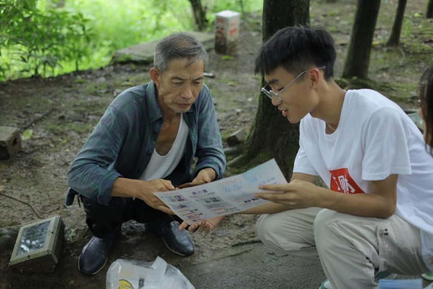 志愿者為村民送相片。共青團(tuán)成都市委供圖